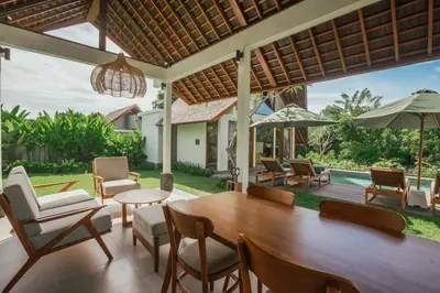 a dining room with a table and chairs and a pool at Arpana Luxury Private Pool Villas in Jimbaran