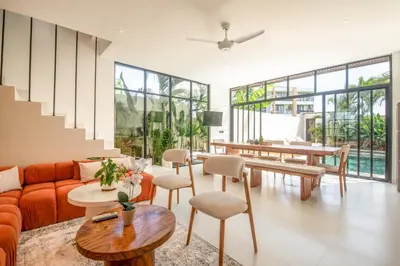 a living room with a orange couch and tables and chairs at Marvelous 6BR 2 mins to Beach in Canggu