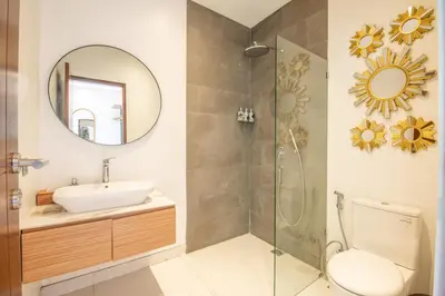 a bathroom with a sink and a shower with a mirror at Marvelous 6BR 2 mins to Beach in Canggu