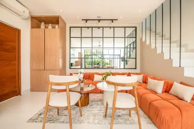 an orange couch in a living room with a table and chairs at Marvelous 6BR 2 mins to Beach in Canggu