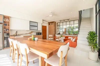 a dining room and living room with a wooden table and chairs at Marvelous 6BR 2 mins to Beach in Canggu