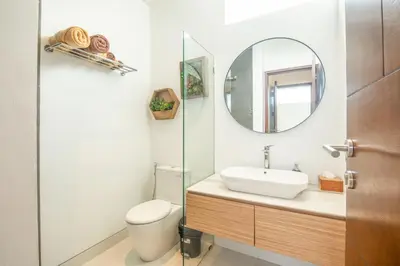 a bathroom with a toilet and a sink and a mirror at Marvelous 6BR 2 mins to Beach in Canggu