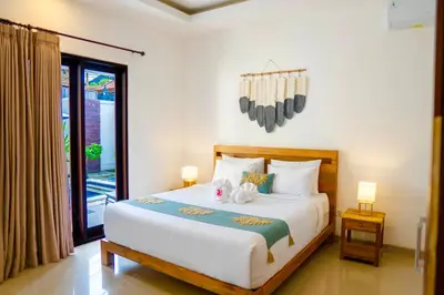 a bedroom with a large white bed with two lamps at Villa Majegau 4 Seminyak in Seminyak