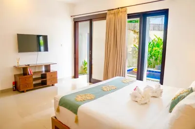 a bedroom with a large bed and a television at Villa Majegau 4 Seminyak in Seminyak