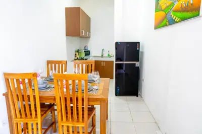 a kitchen with a wooden table with chairs and a refrigerator at Villa Majegau 4 Seminyak in Seminyak