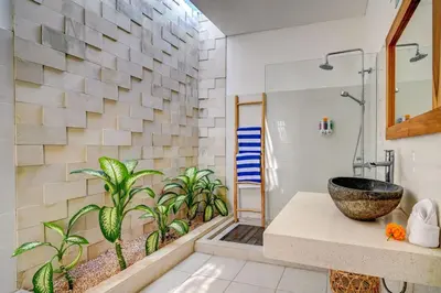 a bathroom with a sink and a shower with plants at Villa Esha II in Seminyak