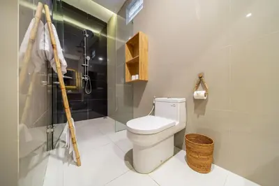 a bathroom with a white toilet and a shower at Sundaze 3 - Villa with Huge Pool and Kitchen in Canggu