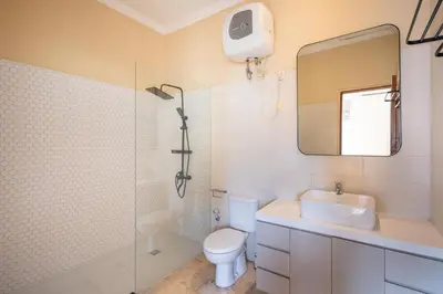 a bathroom with a toilet and a sink and a mirror at Villa Uma Sari in Kerobokan