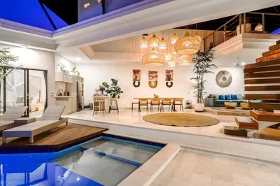 a living room with a swimming pool in a house at Boho-chic Canggu Villa near Cafè Del Mar, 5-minute walk to beach in Canggu
