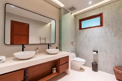 a bathroom with two sinks and a mirror at The Urban Retreat Seminyak Private Pool Villas with Butler for Families & Groups in Seminyak