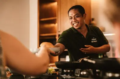 a man standing in a kitchen talking to a woman at The Urban Retreat Seminyak Private Pool Villas with Butler for Families & Groups in Seminyak