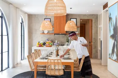a chef standing at a table in a kitchen at Villa Sugi Umalas in Canggu