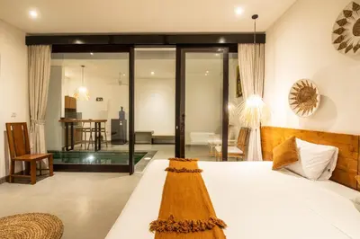 a bedroom with a bed and a living room at Minimalist Villa with Pool #Lina2 in Canggu