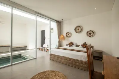 a bedroom with a bed and a sliding glass door at Minimalist Villa with Pool #Jade3 in Canggu