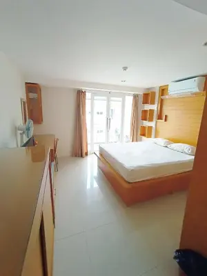 a bedroom with a bed and a large window at Harris Hotel & Residences Kuta in Kuta