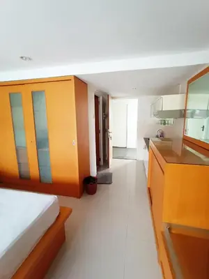a bedroom with a bed and a kitchen with a sink at Harris Hotel & Residences Kuta in Kuta