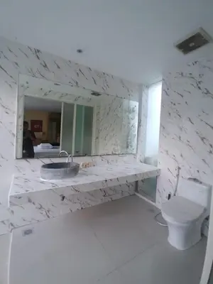 a bathroom with a sink and a toilet and a mirror at 3 Bedroom Calla Villa in Nusa Dua