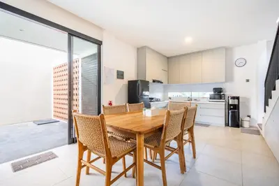 a kitchen and dining room with a wooden table and chairs at Vinca Villa Bali in Kerobokan