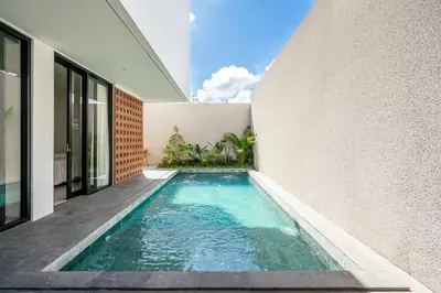 an infinity pool in the side of a house at Vinca Villa Bali in Kerobokan