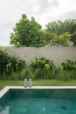 two water bottles sitting next to a swimming pool at Villa NUSA - 3BR Villa in Umalas next to Nook in Kerobokan