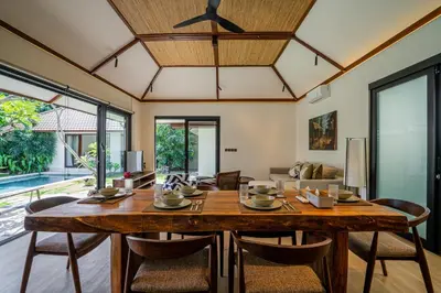 a dining room with a large wooden table and chairs at Villa NUSA - 3BR Villa in Umalas next to Nook in Kerobokan
