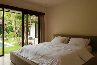 a bedroom with a bed and a large window at Villa NUSA - 3BR Villa in Umalas next to Nook in Kerobokan