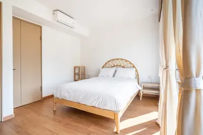 a white bedroom with a bed and a window at IRMAS Villa Bali in Seminyak