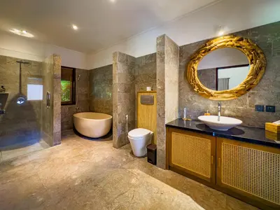a bathroom with a tub and a sink and a mirror at Villa Blubambu in Seminyak