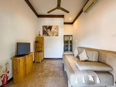 a living room with a couch and a tv at Villa Blubambu in Seminyak