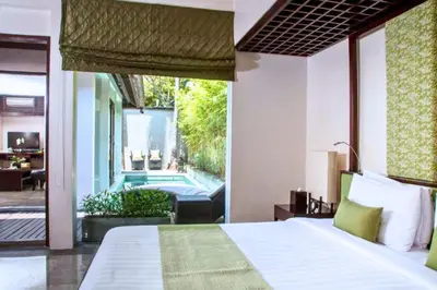 a bedroom with a bed and a swimming pool at Liam 1 BR Bamboo Private Pool Villa JU63 in Seminyak
