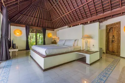 a bedroom with a bed and a table in a room at Bali Villa Home in Seminyak