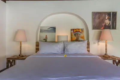 a bedroom with a large bed with two lamps at Bali Villa Home in Seminyak