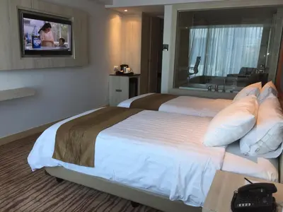 a hotel room with two beds and a television at Sovereign Bali Hotel in Kuta