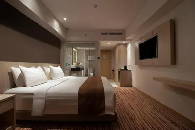 a hotel room with a large bed and a television at Sovereign Bali Hotel in Kuta