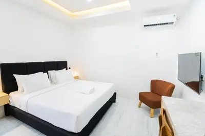 a bedroom with a white bed and a chair at Alyxia 1 Bedroom Apartment in Central Seminyak in Seminyak