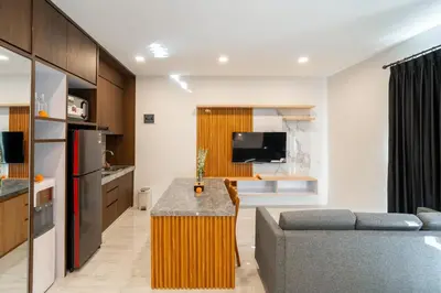 a kitchen and living room with a couch and a television at Alyxia 1 Bedroom Apartment in Central Seminyak in Seminyak