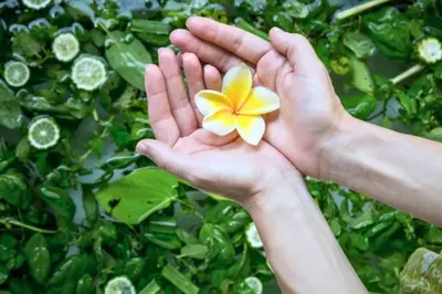 a person holding a flower in their hands at Nisara 2 BR Garden Pool Villas JU67 in Seminyak