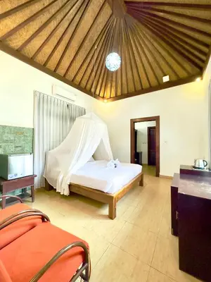 a bedroom with a bed with a mosquito net at Bali Stuti Jimbaran Inn in Jimbaran