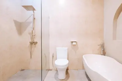 a bathroom with a toilet and a bath tub at Villa Koura Kuta in Kuta
