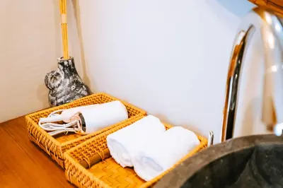 a bathroom with two baskets with towels and a sink at Villa Koura Kuta in Kuta