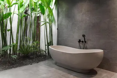 a bath tub in a bathroom with plants at Villa Under the Sun - Seminyak in Seminyak