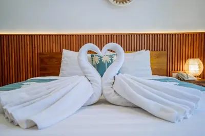 two swans made out of towels sitting on a bed at MIMU C-O Living in Kerobokan