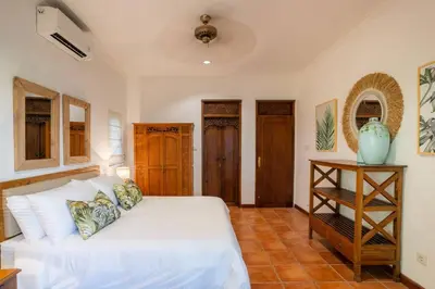 a bedroom with a white bed and a table at Villa Pande Sanur Beach Side in Sanur