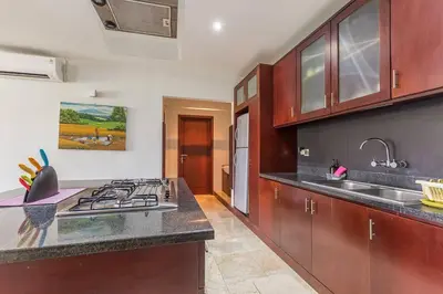 a kitchen with a sink and a stove top oven at Quiet Central Seminyak 2bd 2 bath and walk to eat st in Seminyak