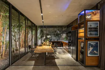 a dining room with a table and some plants at Luxury Industrial Villa with Sauna and Highend Amenities in Seminyak