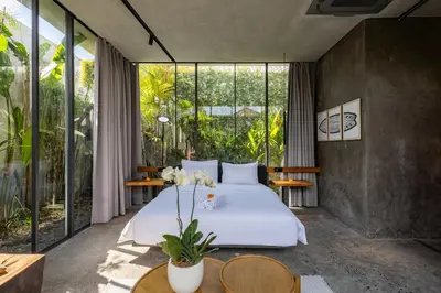 a bedroom with a bed and large windows at Luxury Industrial Villa with Sauna and Highend Amenities in Seminyak