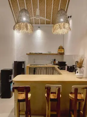 a kitchen with a counter with chairs and lights at Nawa Villa private pool 3bedrooms in Seminyak