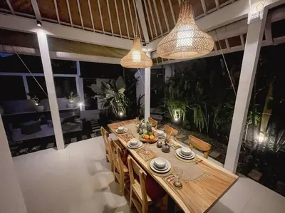 a dining room with a wooden table with chairs and lights at Nawa Villa private pool 3bedrooms in Seminyak