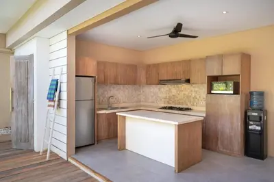 a kitchen with wooden cabinets and a ceiling fan at Villa Ewa 1 in Seminyak