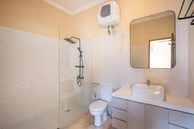 a bathroom with a toilet and a sink and a mirror at Villa Uma Sari c9 in Seminyak